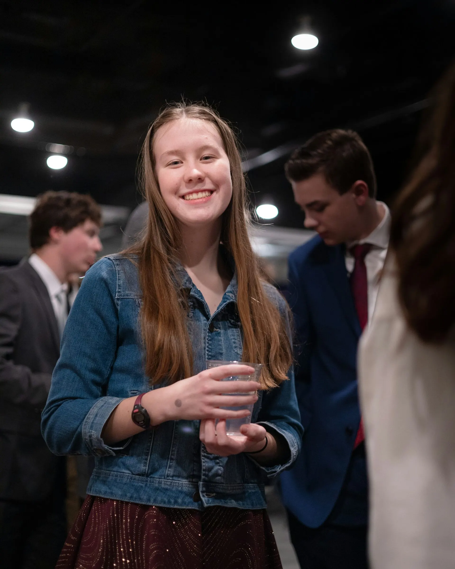 A student smiling at an evening networking event